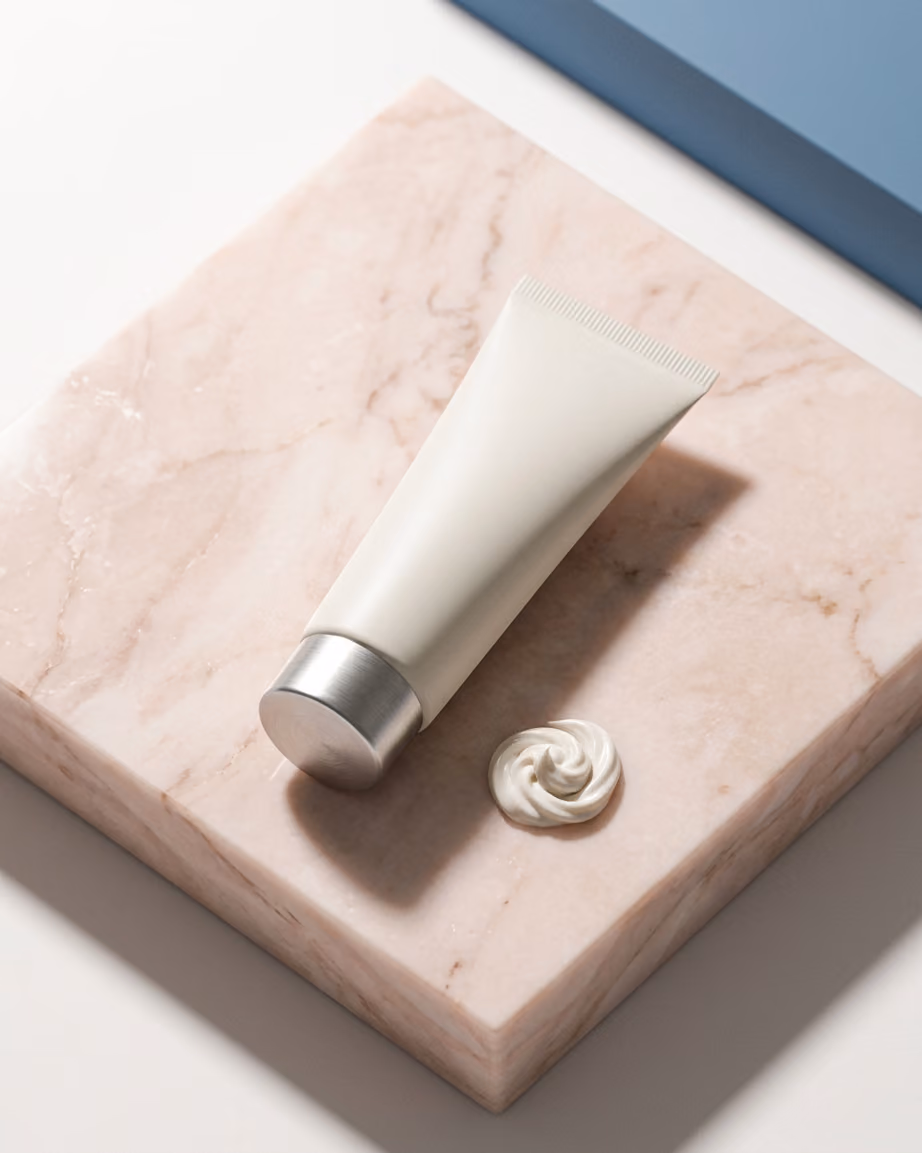 Hand cream tube on pink stone with soft shadow